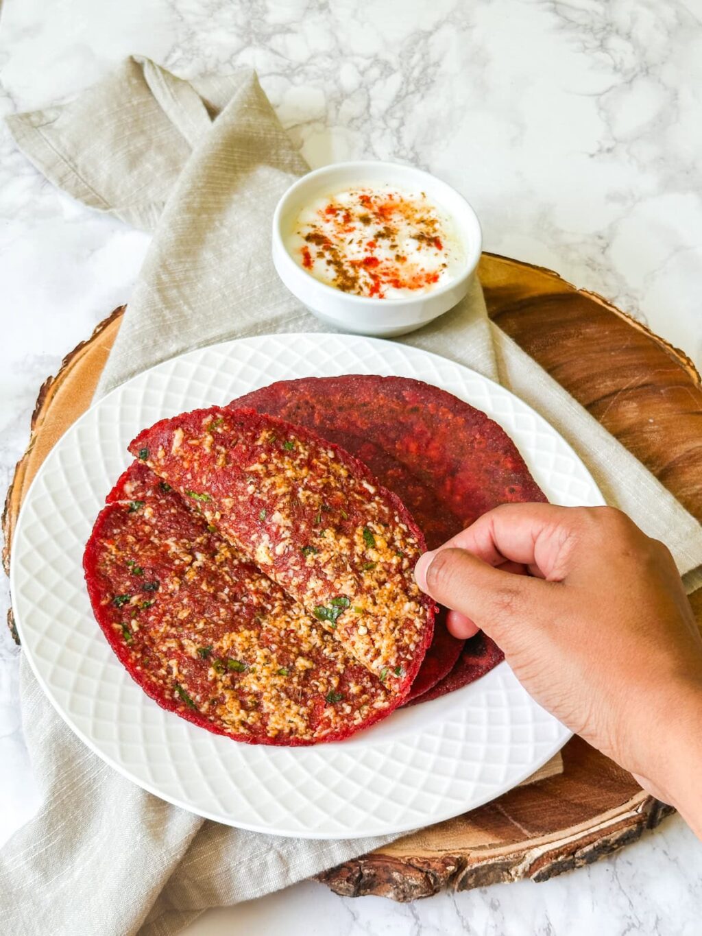 Opened up beetroot paratha showing inside stuffing.