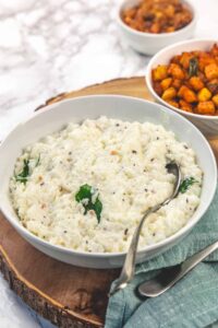 Curd rice in a bowl with spoon.